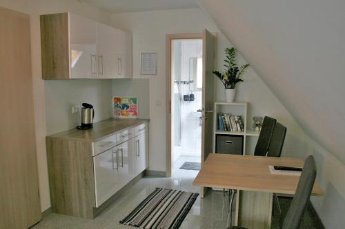 eine Küche mit einem Tisch und eine Küche unter der Treppe in der Unterkunft Haus zum Schlosspark in Veitshöchheim