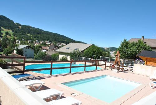uma grande piscina com espreguiçadeiras e um resort em Camping les Auches em Ancelle