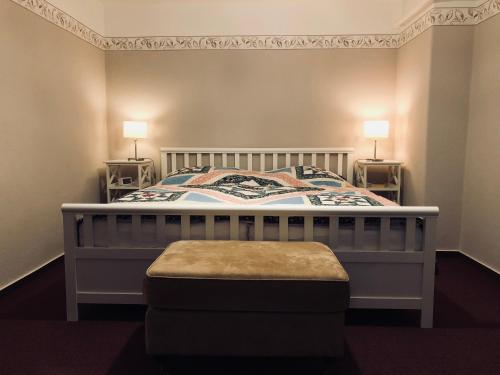 Schlafzimmer mit einem Bett mit einem Fußbrett und einem Hocker in der Unterkunft Ferienwohnung Südel in Malente