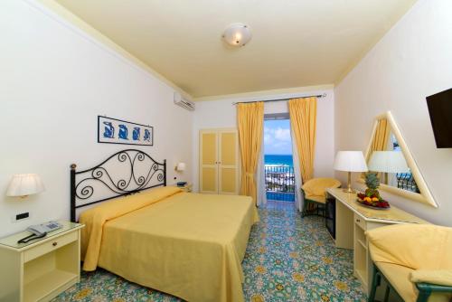 a hotel room with a bed and a balcony at Hotel Villa Bianca in Ischia