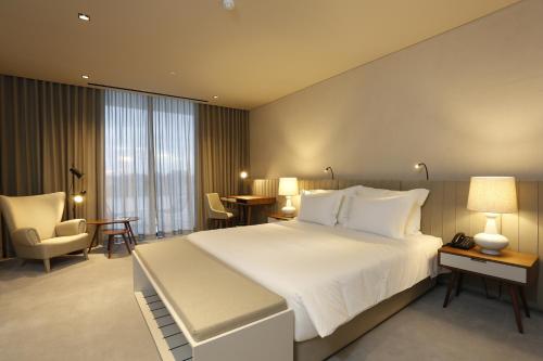 a bedroom with a large white bed in a room at Montebelo Vista Alegre Ílhavo Hotel in Ílhavo