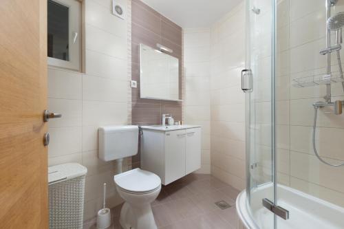 a white bathroom with a toilet and a shower at Andrea in Makarska