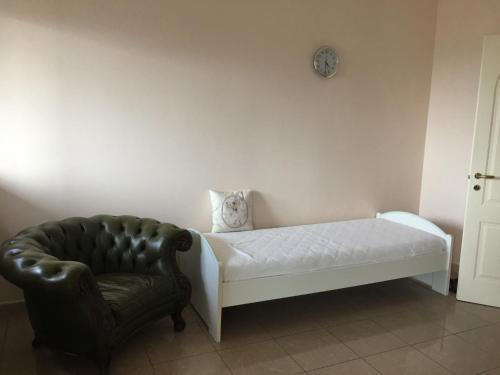 a bedroom with a bed and a chair and a clock at La tua casa a Matera in Matera