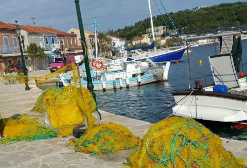 a group of nets on a dock with boats in the water at Foki Beach House in Fiskardho