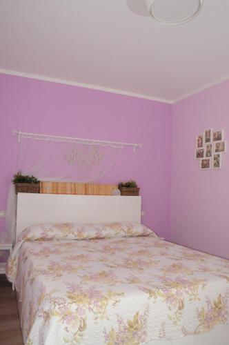 ストリにあるIl Maestro e l'Innamorataの紫の壁と白いベッドが備わるベッドルーム1室
