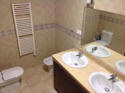 uma casa de banho com 2 lavatórios, um WC e um espelho. em Appartement El Bahia Saidia destiné uniquement aux couple mariés, célibataires s'abstenir em Saidia 
