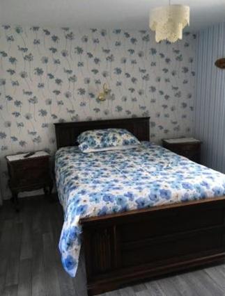 a bedroom with a bed with a floral comforter at Beau Vista in Strabane