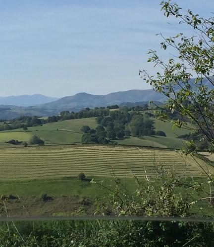 a view of a field with mountains in the background at Ama Lur in Hasparren