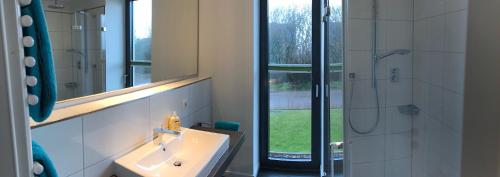 a bathroom with a sink and a mirror and a shower at Tor zum Meer in Helgoland