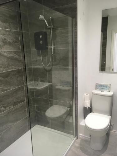 W łazience znajduje się toaleta i przeszklony prysznic. w obiekcie Royale Court Apartments Portrush w mieście Portrush