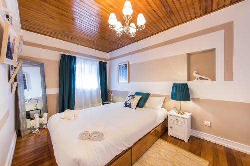 リスボンにあるPicoas Artistic Flatの木製の天井のベッドルーム(白い大型ベッド1台付)