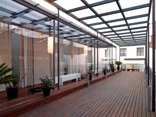 a balcony with glass walls and a wooden deck at Hospes Palau de La Mar, Valencia, a Member of Design Hotels in Valencia