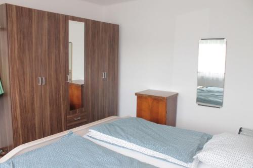 - une chambre avec un lit et une armoire en bois dans l'établissement Apartmán Lužnická, Soběslav, à Soběslav