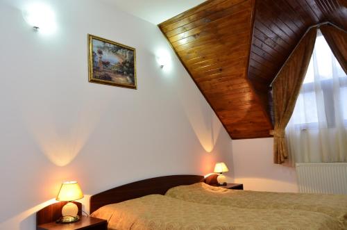 サチェレにあるMotel din Darsteの木製の天井が特徴のベッドルーム1室(ベッド2台付)