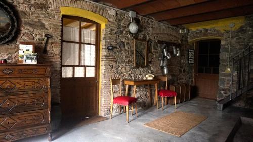 a kitchen with a table and two red chairs at Mas Gibert in Sant Gregori