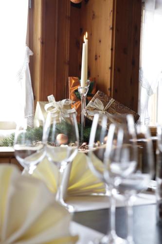 a group of wine glasses on a table with a candle at Hotel Ducan in Monstein