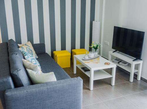 uma sala de estar com um sofá, uma televisão e uma mesa em Sea Breeze Boutique em Cavala