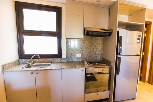a kitchen with a stainless steel refrigerator and a window at Sky View Suites Hotel in Hurghada