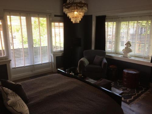 a bedroom with a bed and a chandelier and windows at Florentino in Eindhoven