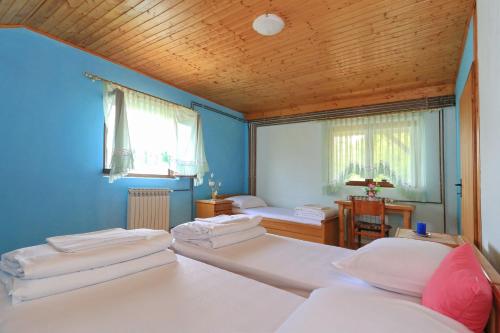 a bedroom with three beds and a wooden ceiling at Villa Barbara in Vrlika