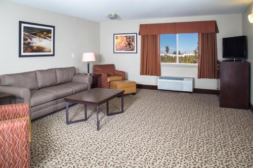 a living room with a couch and a tv at Gray Wolf Inn & Suites in West Yellowstone