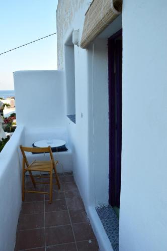 a table and a chair sitting on a balcony at Le Case del Capitano in Stromboli