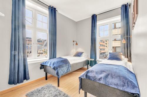 zwei Betten in einem Zimmer mit zwei Fenstern in der Unterkunft Forenom Serviced Apartments Oslo City Hall in Oslo
