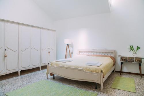 ベルガモにあるAppartamento Arlecchinoのベッドルーム1室(白いキャビネットと緑のラグ付)