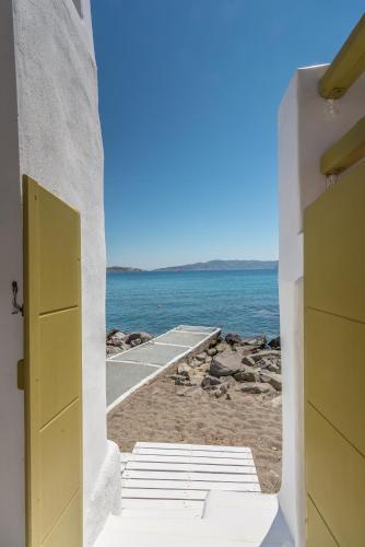 a view of the beach from a house with an open door at villa lord in Pollonia