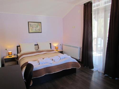 a bedroom with a bed with towels on it at Bavaria House in Govedartsi