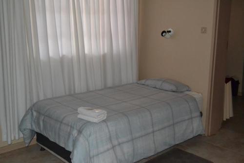 a bedroom with a bed with two towels on it at Kenhardt Hotel in Kenhardt