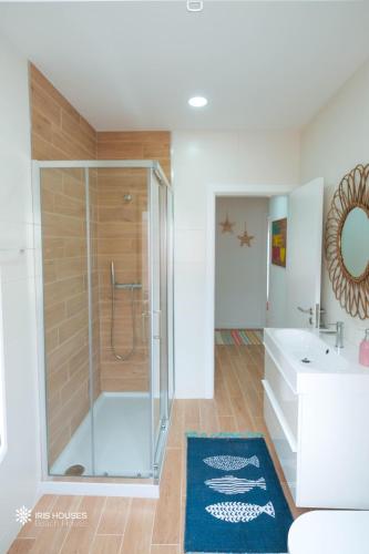 a bathroom with a glass shower and a tub at Iris Apartment in Nazaré