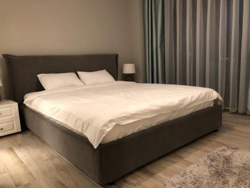 una camera da letto con un grande letto con lenzuola bianche di Sea View Mamaia a Mamaia