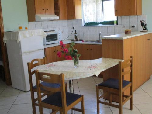 a kitchen with a table with a vase of flowers on it at Ammodares in Lixouri