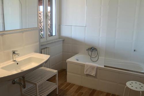 a white bathroom with a sink and a bath tub at Hotel Tuscania Panoramico in Tuscania