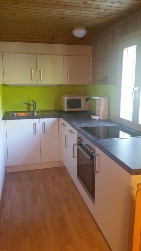 a kitchen with white cabinets and a sink at Haus Silke in Silbertal