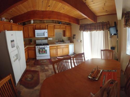 a kitchen with a table and a white refrigerator at Cabin on the Corner in Big Bear Lake