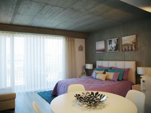 a bedroom with a bed and a table and a window at Family Studio Aveiro in Aveiro