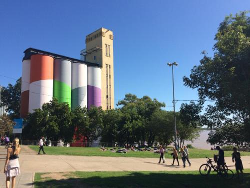 a group of people walking around a park with a clock tower at Studio Río in Rosario