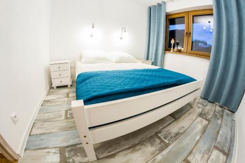 sypialnia z łóżkiem i niebieską zasłoną w obiekcie "Między Gruszką a Sanem" w mieście Lesko