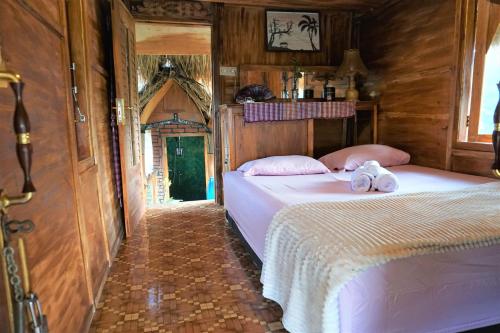 a bedroom with two beds with white sheets at Satu Lingkung in Tetebatu