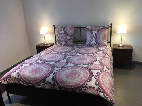 a bedroom with a pink bed with two lamps at Gîte Grewis in La Wantzenau