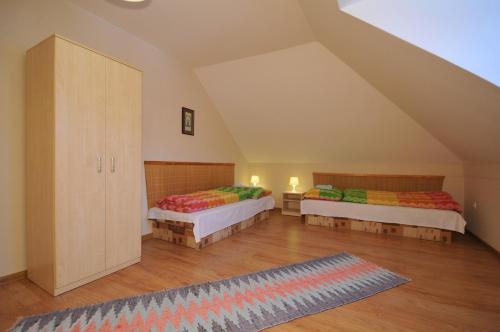 Habitación en el ático con 2 camas y alfombra en Penzion Chalupka, en Spišské Podhradie