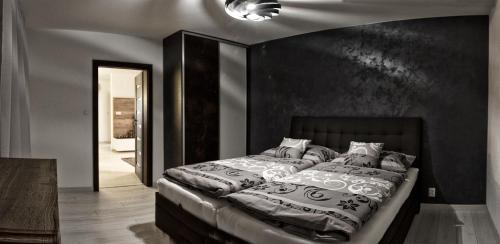 1 dormitorio con 1 cama con pared negra en Apartment Centrum Luxury Mountain View en Poprad