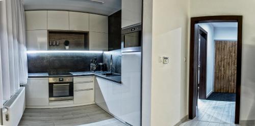a kitchen with stainless steel appliances and a hallway at Apartment Centrum Luxury Mountain View in Poprad