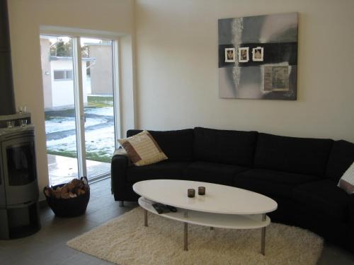 a living room with a black couch and a white coffee table at Sudersand Resort in Fårö