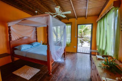 ein Schlafzimmer mit einem Himmelbett in der Unterkunft Cabier Ocean Lodge in Crochu