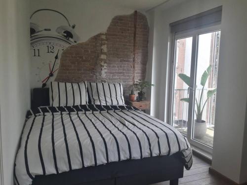 a bedroom with a bed with a large clock on the wall at Da Costastraat in Amsterdam