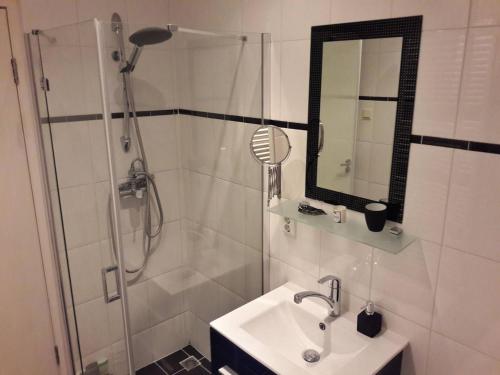 y baño con ducha, lavabo y espejo. en Da Costastraat, en Ámsterdam