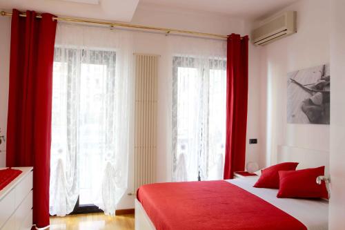 a bedroom with red curtains and a red bed at Apartment De Rossi in Bari